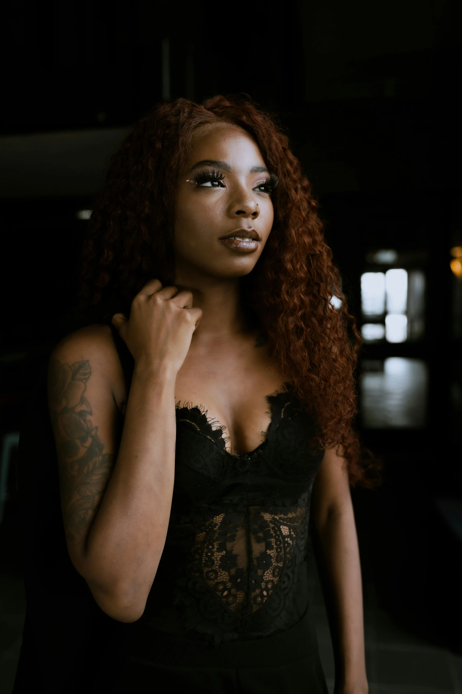 a woman with curly hair standing in the dark