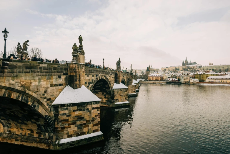 bridge in the middle of snowy river with a lot of people