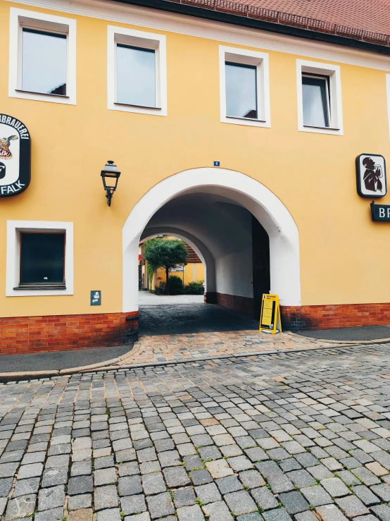 a tunnel entrance on the side of a yellow building