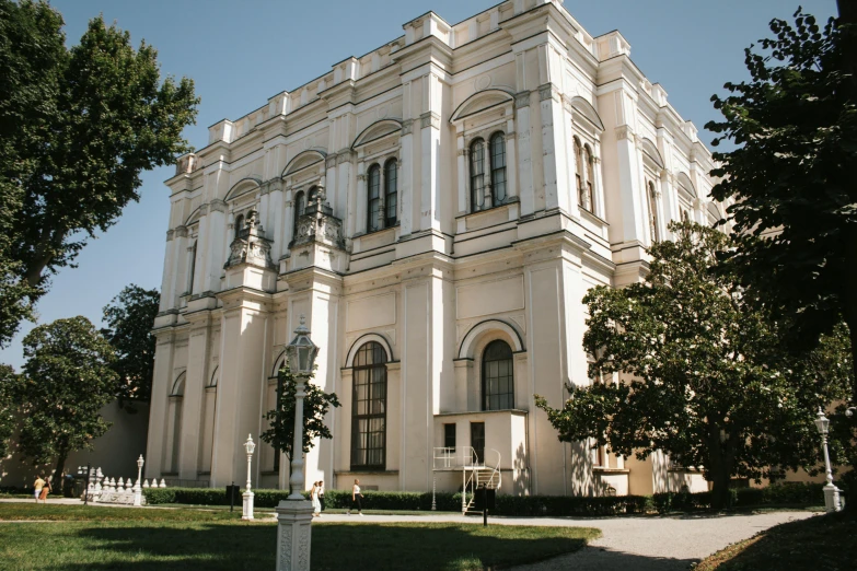 large white building with ornate columns near some trees