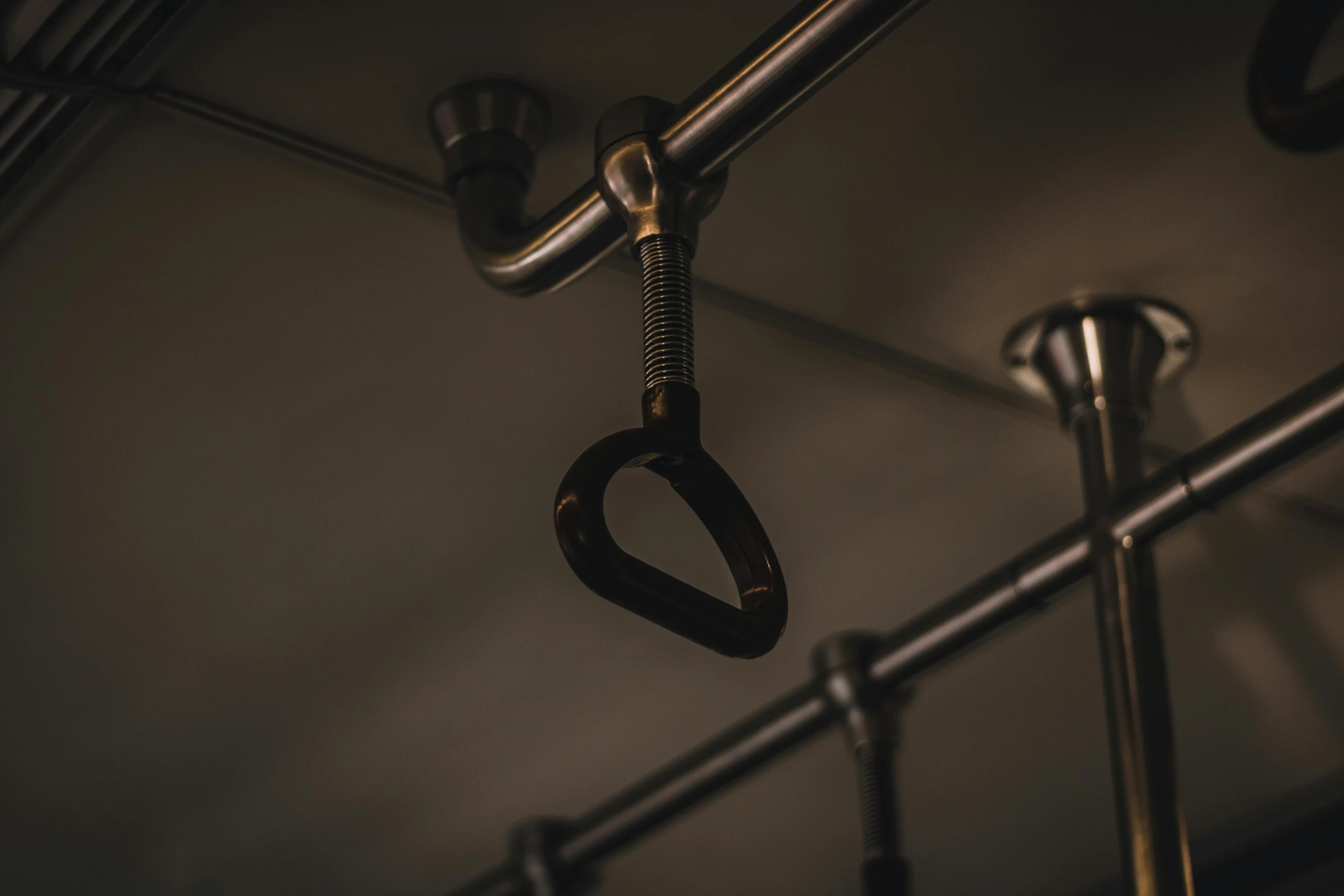 a pair of metal hooks hang from the side of an iron rack