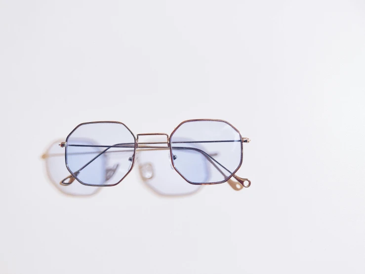 a pair of glasses sitting on top of a white surface