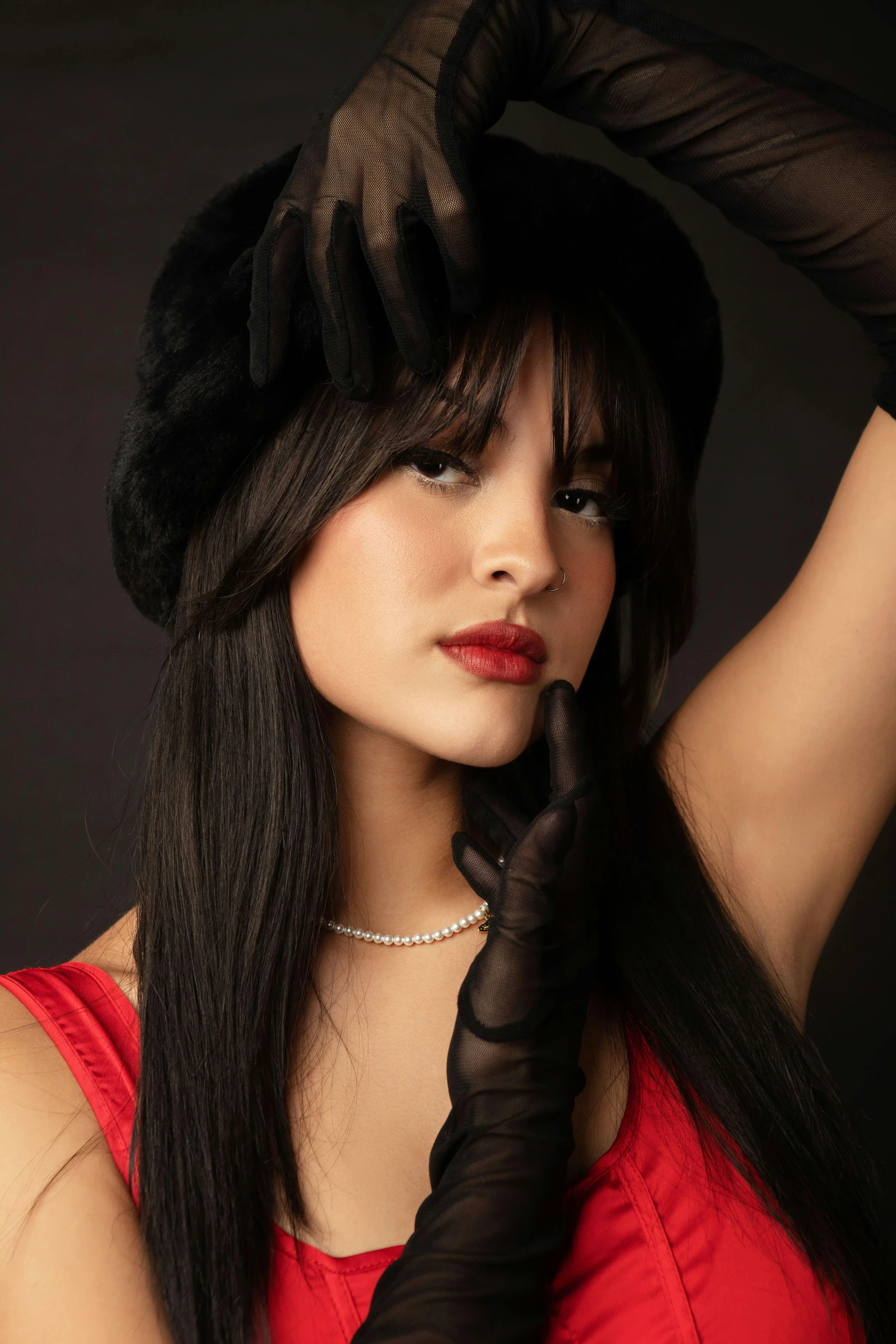 a woman with long black hair is wearing gloves