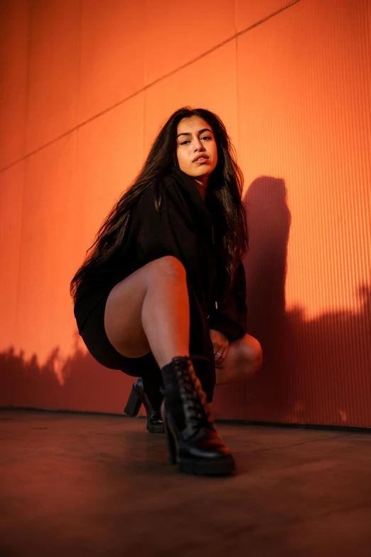 a woman is kneeling down wearing boots and dress