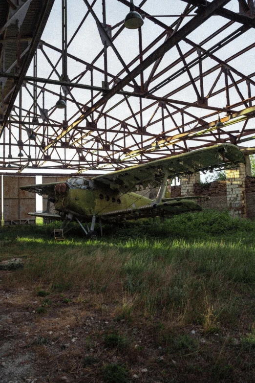 an old dilapidated building with old airplanes sitting underneath