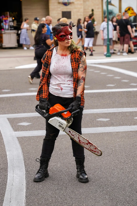 a person that is standing in the street with a chainsaw