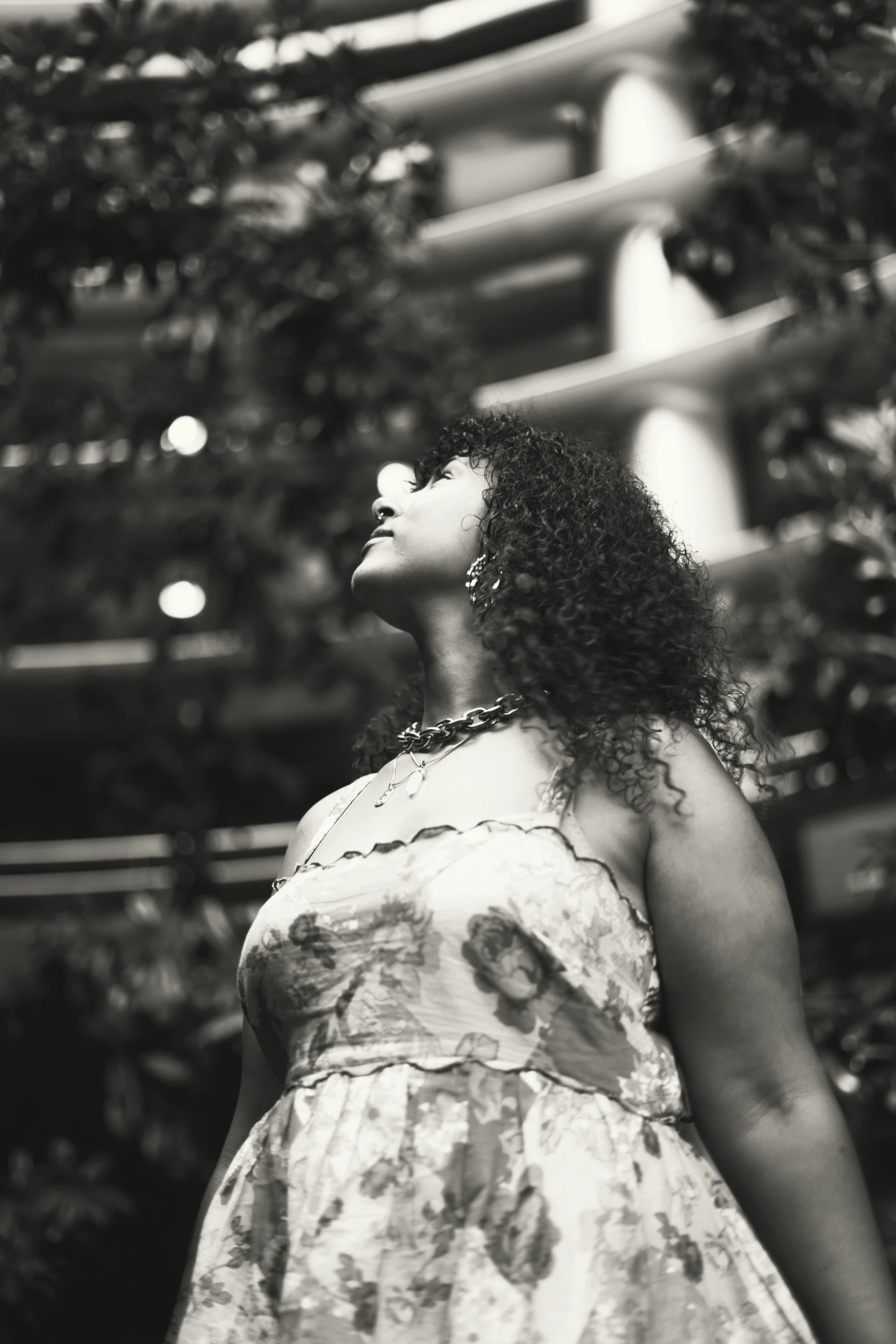 a woman with curly hair is standing alone outside