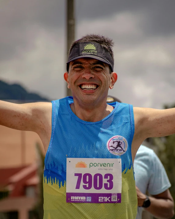 man standing on top of a race finish line with his arms in the air