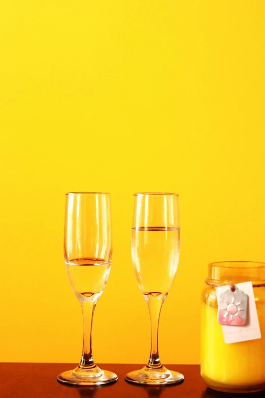 three glasses that are on a table with a jar