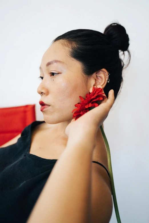 a woman wearing a red flower on top of her hair