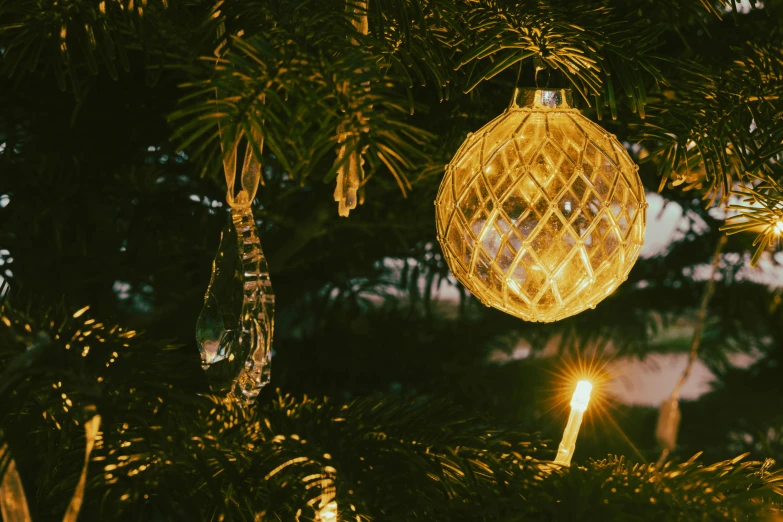 a christmas ornament hangs from a tree with other lights