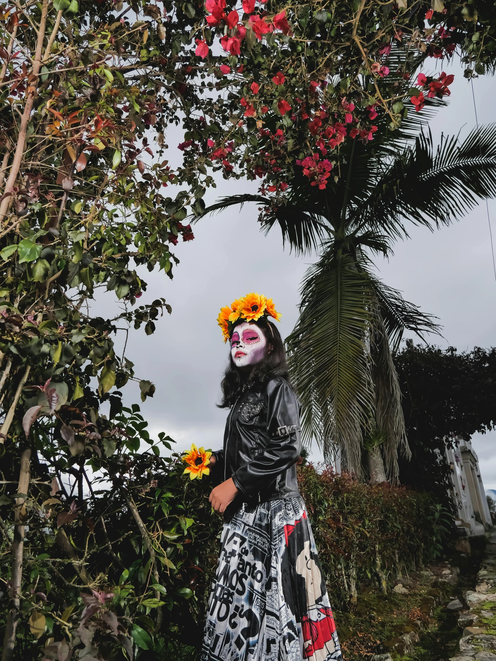 a woman wearing a costume holding a sunflower stands in front of trees