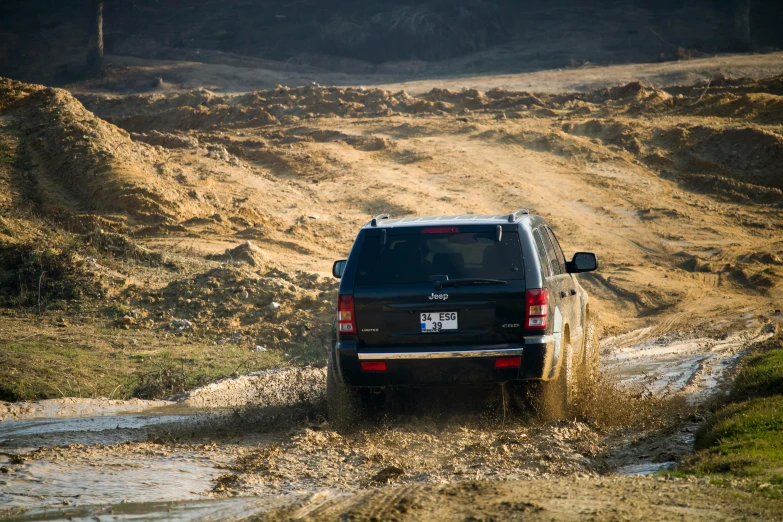 the jeep is going through a very muddy stream