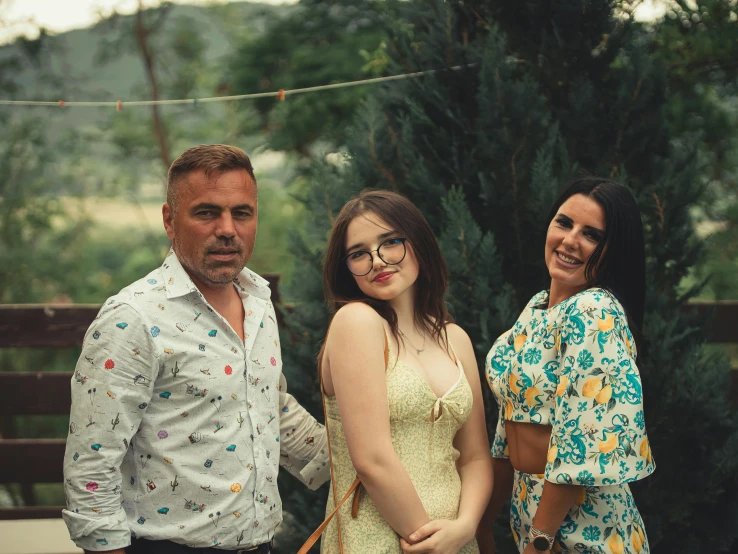 three people, one woman and one man standing together