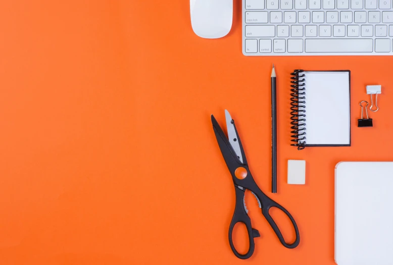 some office supplies on a bright orange surface