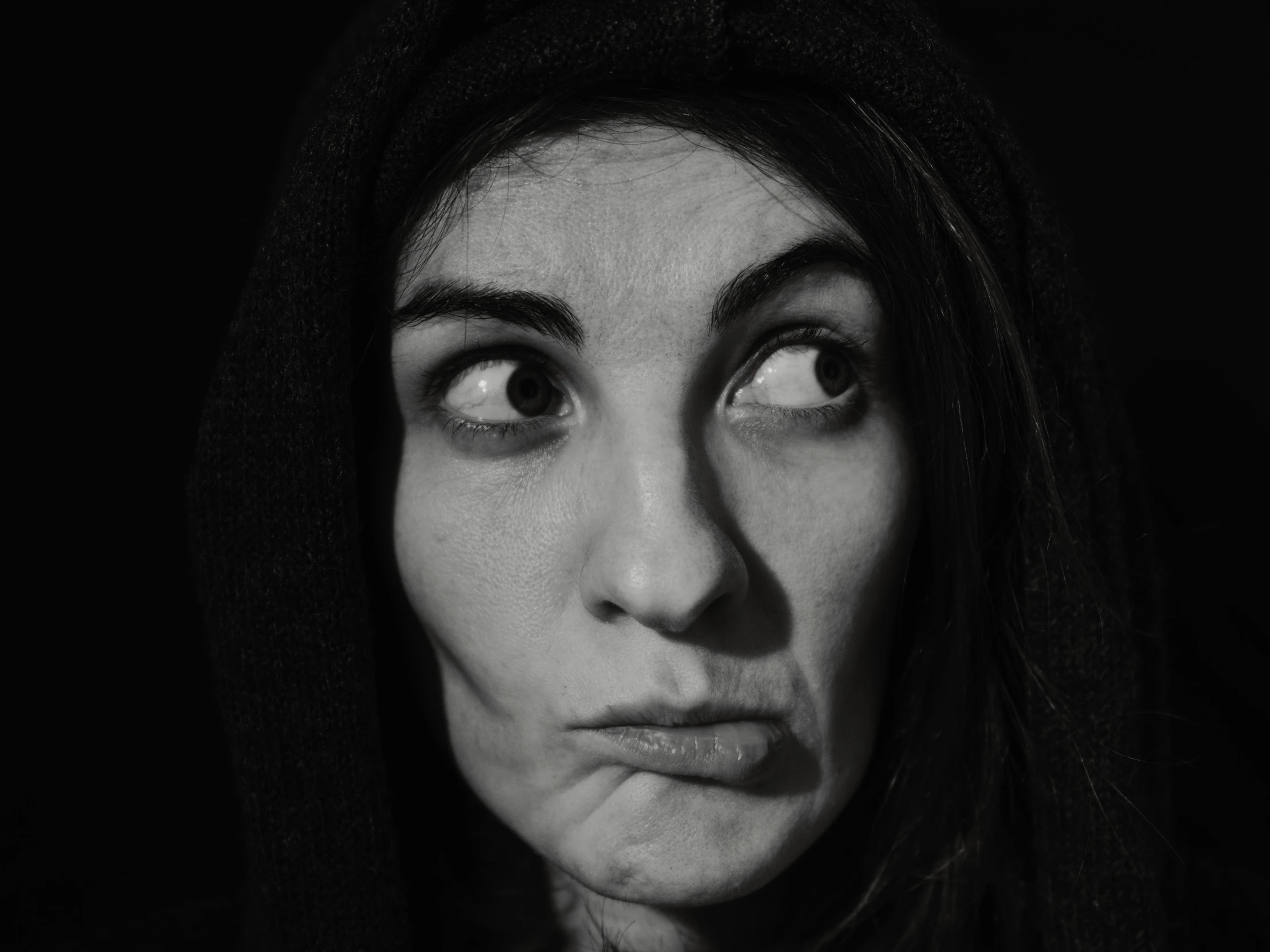 a woman's face, black and white pograph, with dark background