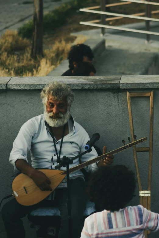 an older man with long white hair is playing a guitar