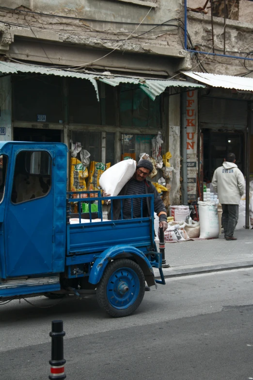 a blue truck that is sitting on the road