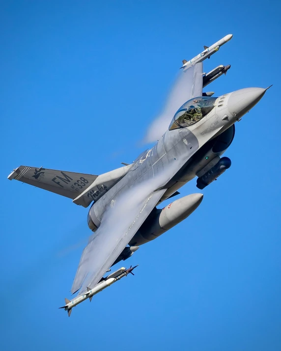 a grey fighter jet in mid air during daytime