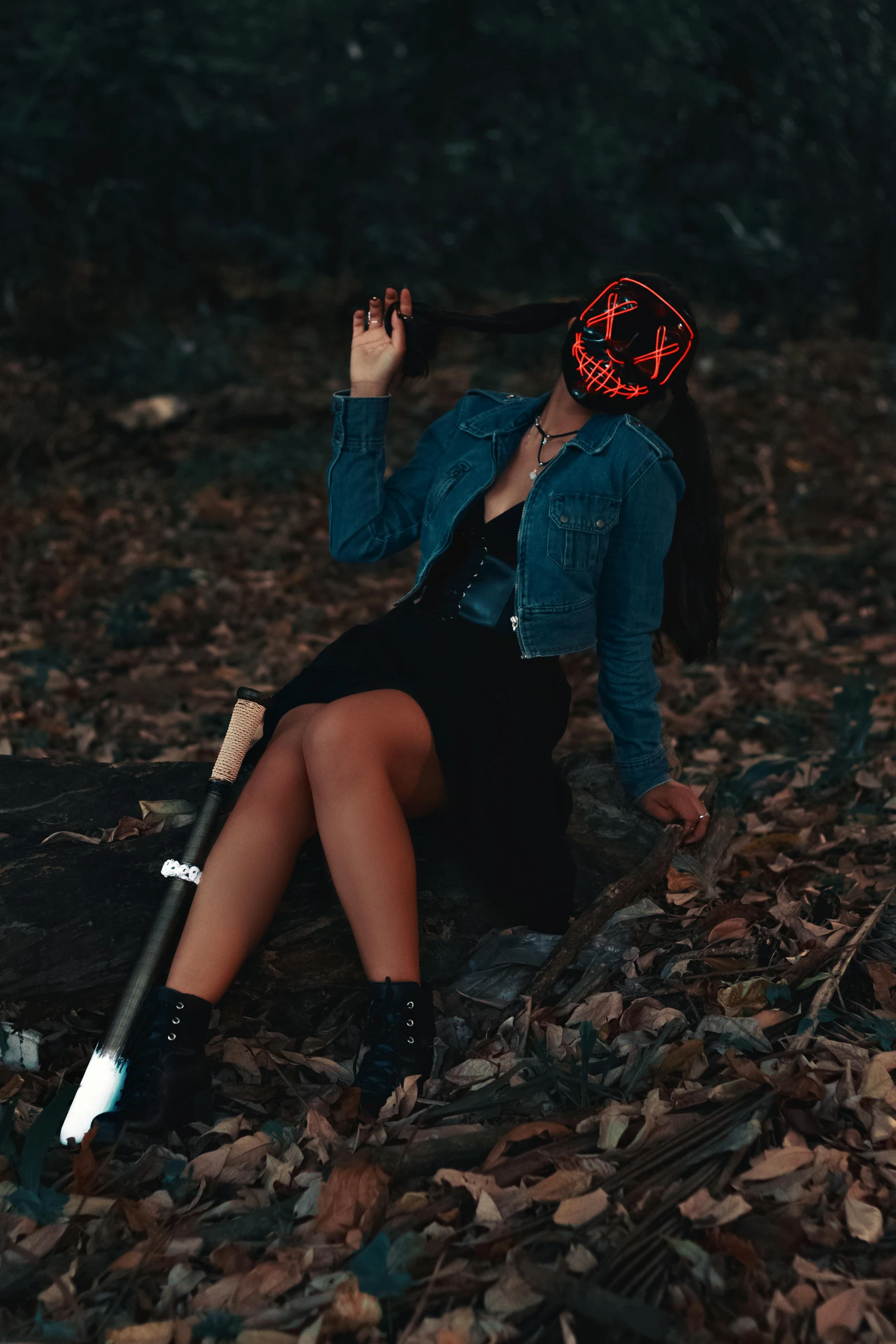 a woman in a dark forest with her hand on the back of an umbrella