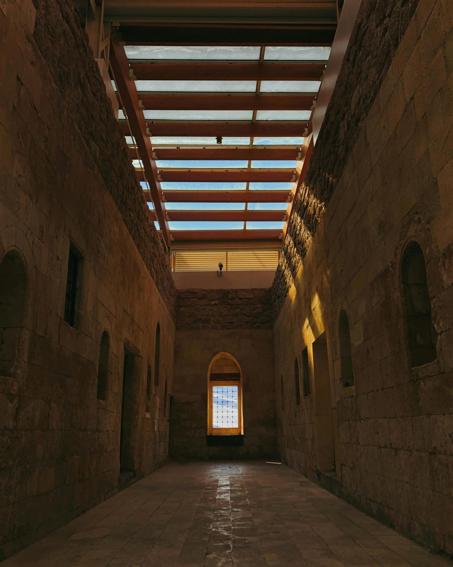 the inside of an empty brick building is shown with sun shining through it