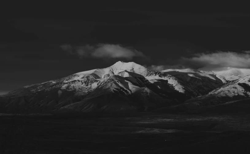 black and white pograph of mountains under a cloudy sky