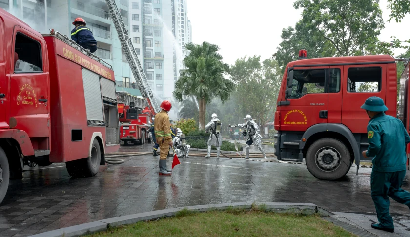 firefighters standing by the fire trucks near the building