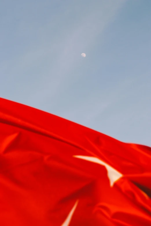 a red flag with the image of a star on it in the wind