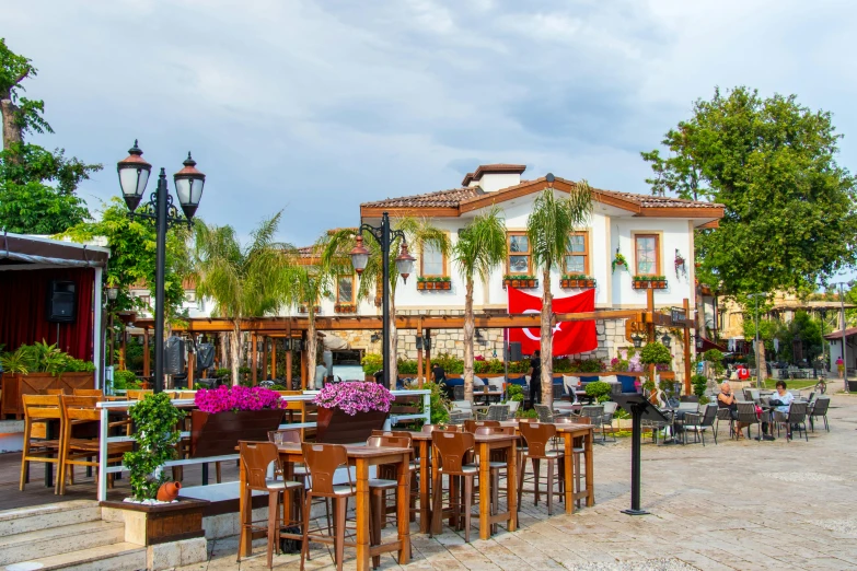 people sit outside a cafe near many trees