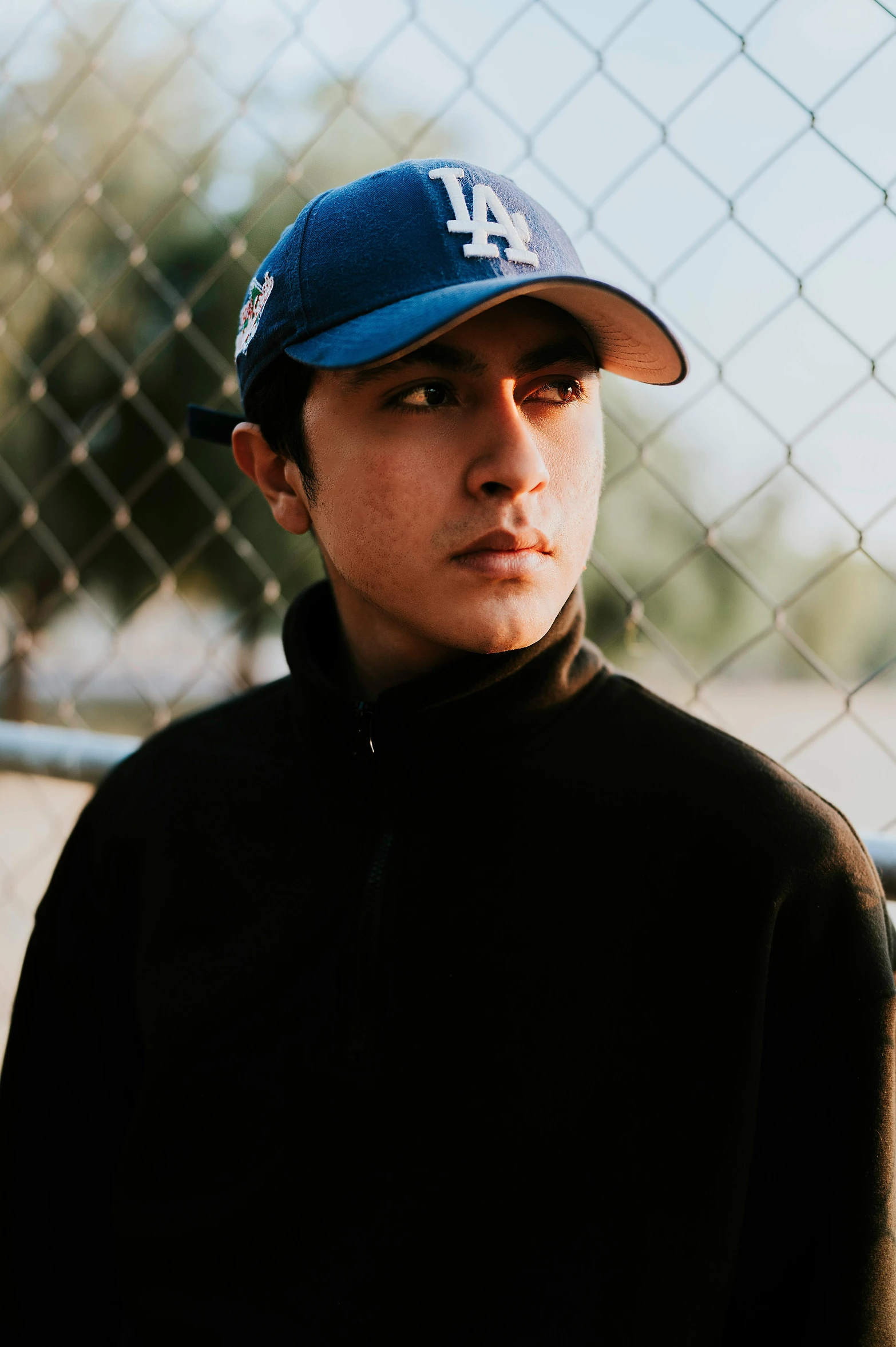 a man wearing a dodgers cap poses for a pograph