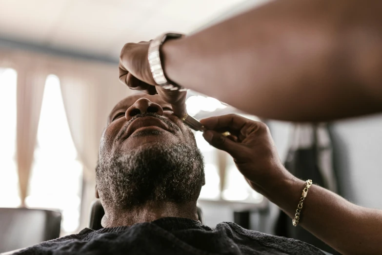 a man in a barbershop cuts a mans hair