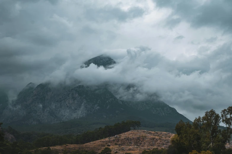 a mountain range on a cloudy day with thick clouds