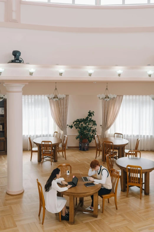 a man and woman are sitting at the table and working