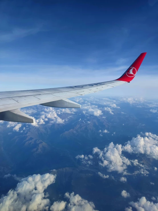 a plane wing looking out over the clouds