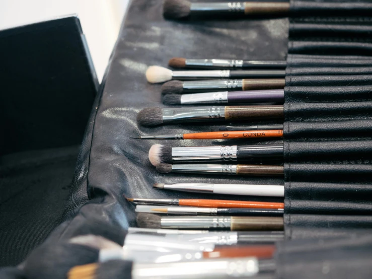 a variety of makeup brushes lined up on a counter