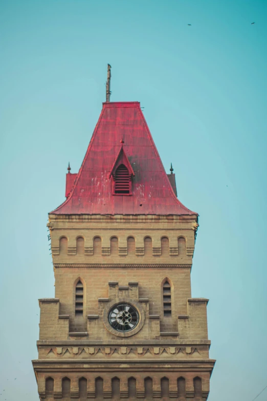 the top of a tower with a clock in front of a clear blue sky