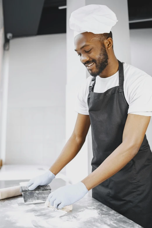 a man in an apron  a pizza on a pan