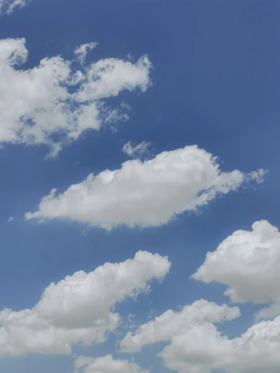 several different clouds in the blue sky