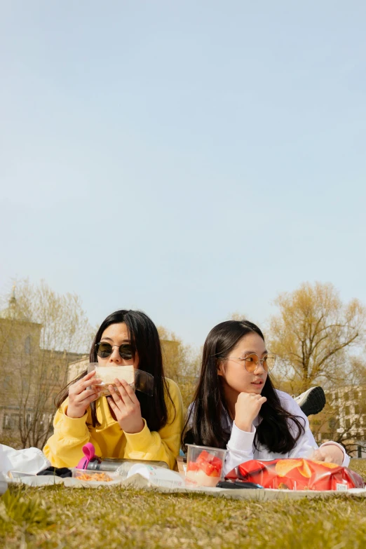 two women are eating at a picnic together