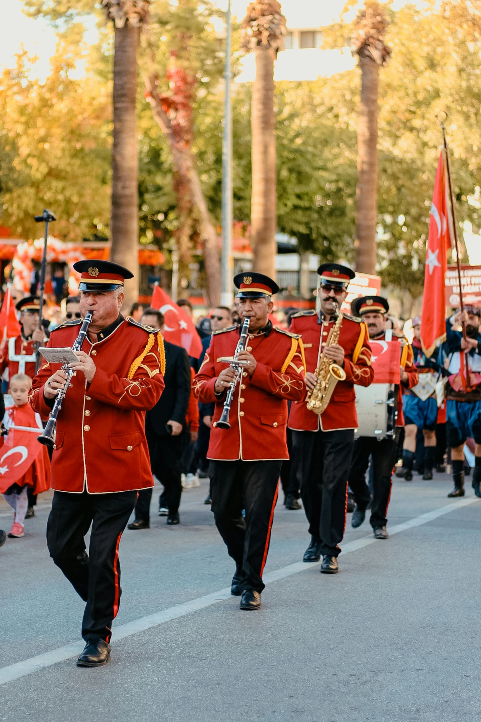 a band marching down a street with people dressed in red