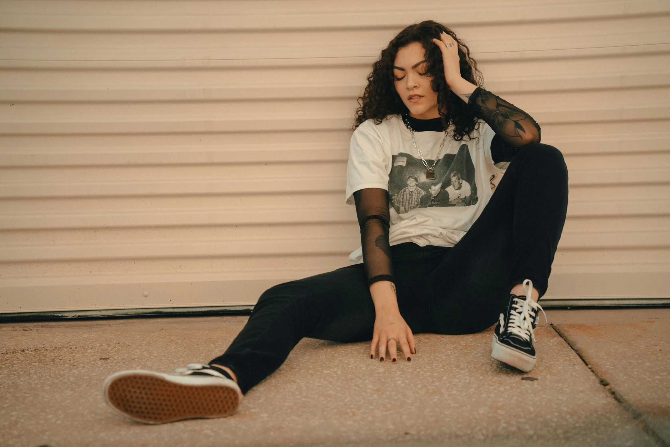 young woman sitting on concrete with tennis shoes