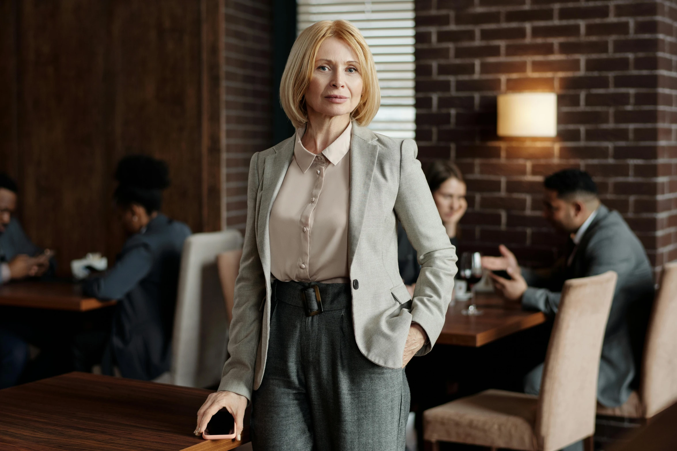 woman standing in a restaurant area surrounded by people