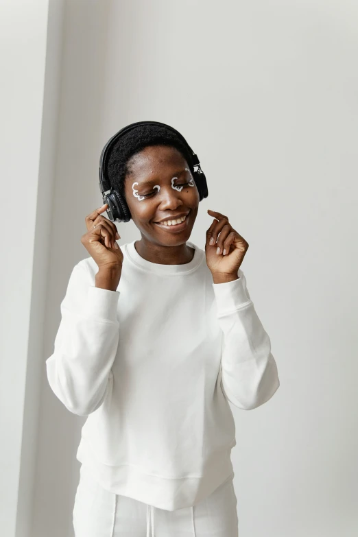 a woman wearing a pair of black headphones is smiling