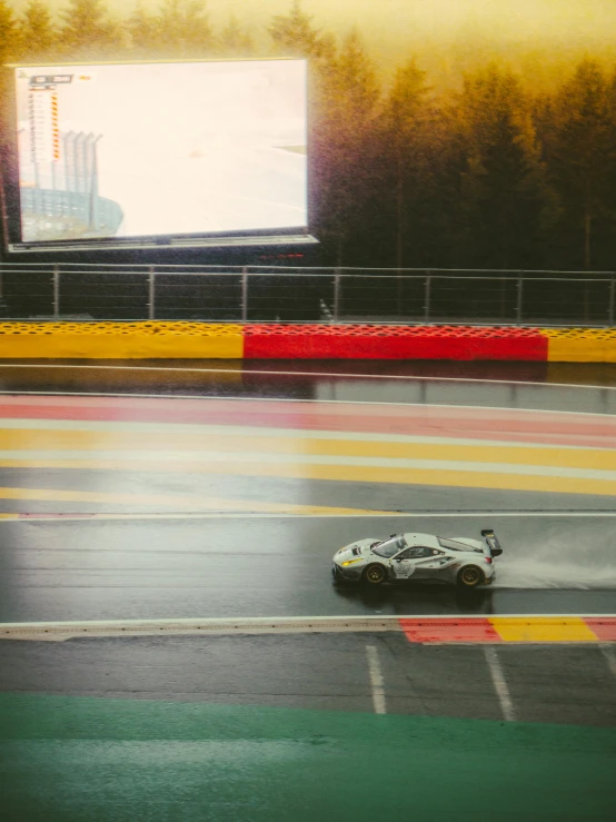 two racing cars traveling down the rain covered track