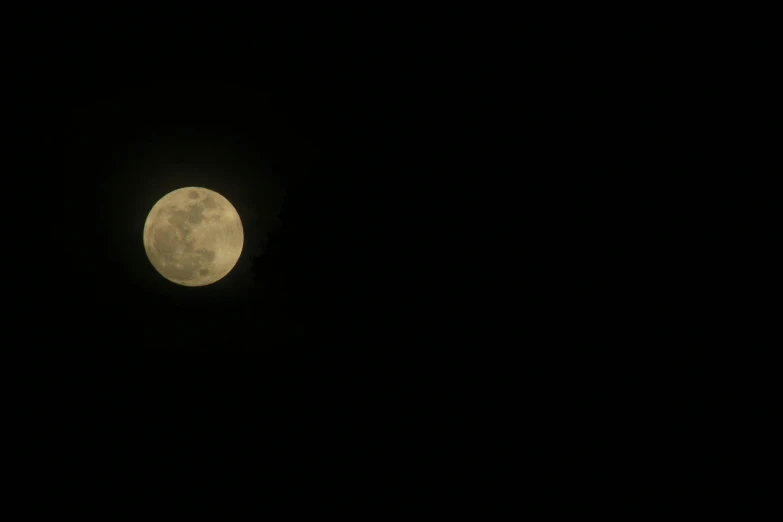 a full moon seen through the dark sky