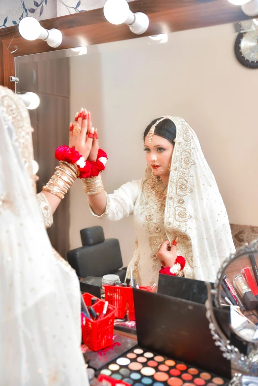 a bride holding her red flowers for another to take a picture