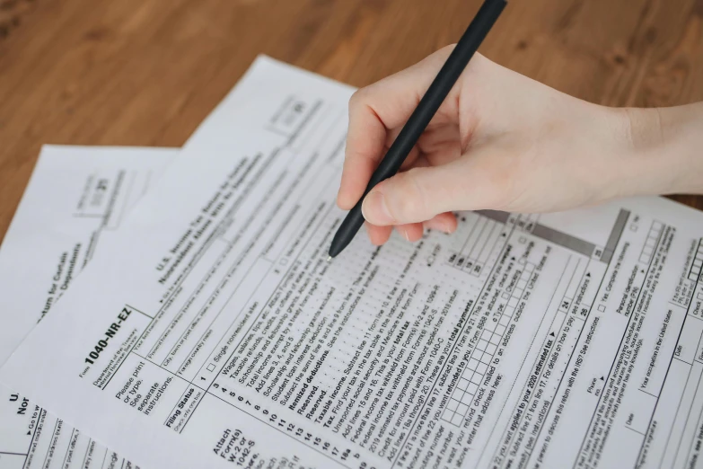 woman's hand holding a pencil and on top of a piece of paper