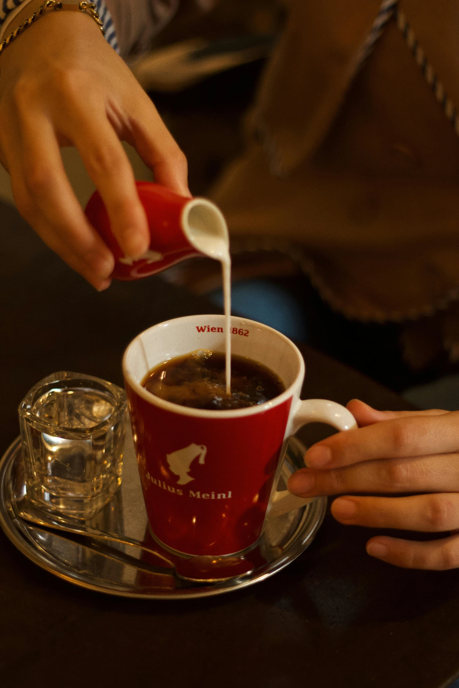 a person pouring some white liquid into a cup