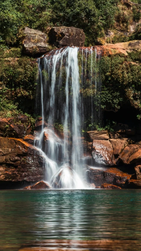 a waterfall is high above the water in the middle of nowhere