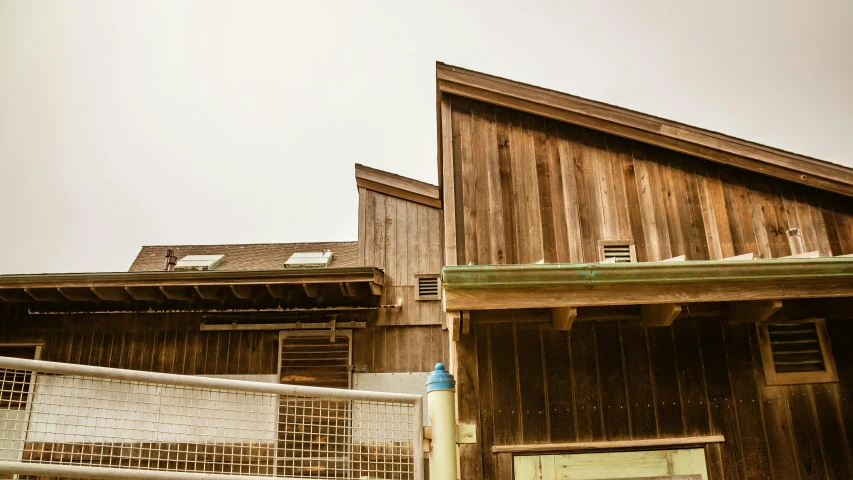 a house with a wood shingled building that has windows